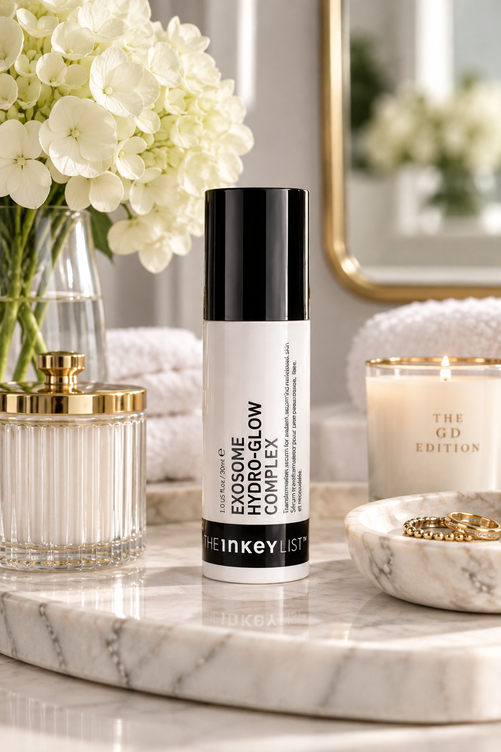 Exosomes in Skincare: What They Are, How They Work & 3 Serums to Know in 2026 The INKEY List Exosome Hydro-Glow Complex Serum styled on a marble vanity tray with white hydrangeas, gold accents and luxury bathroom decor.